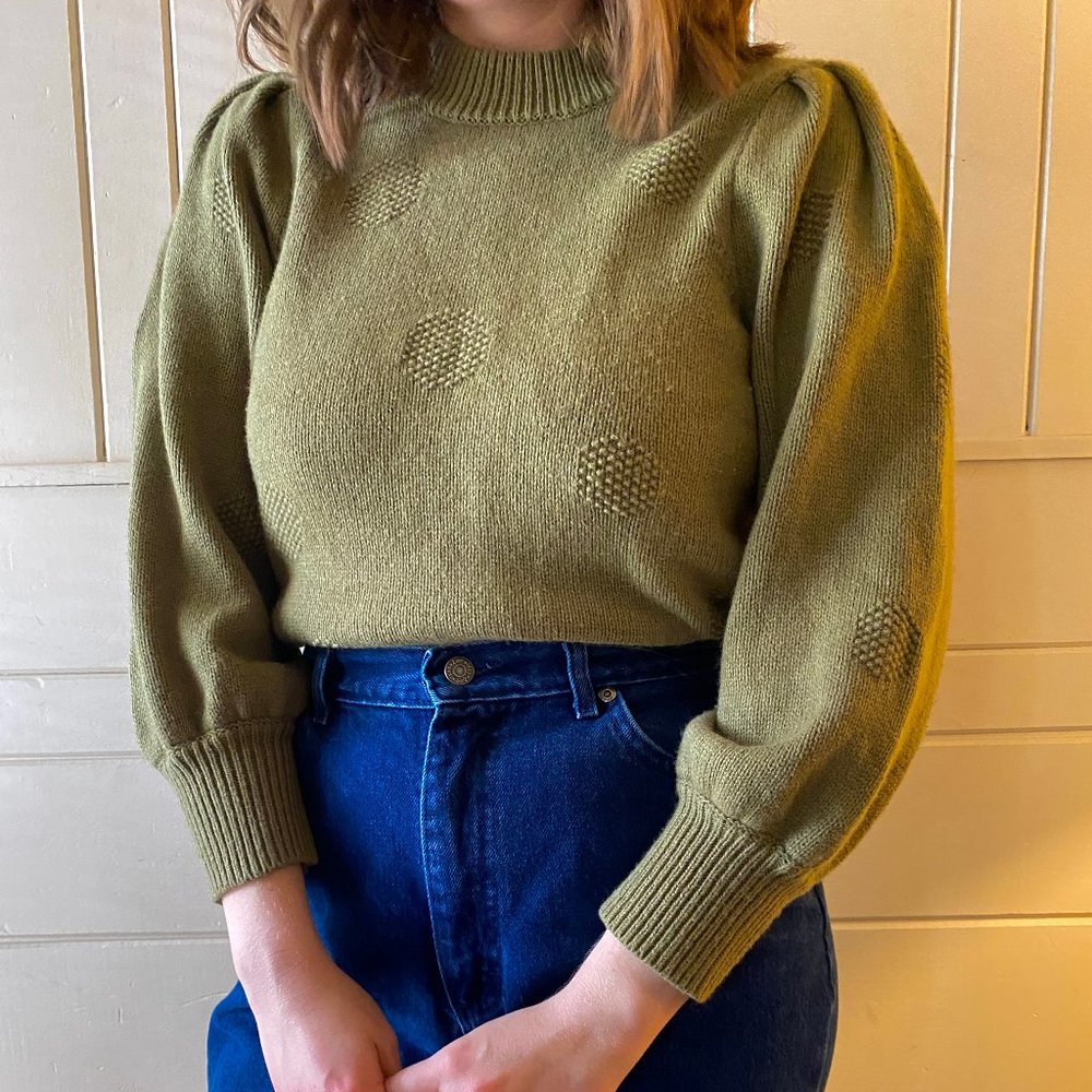 Olive green sweater with slightly puffed sleeves and polka dot knit pattern